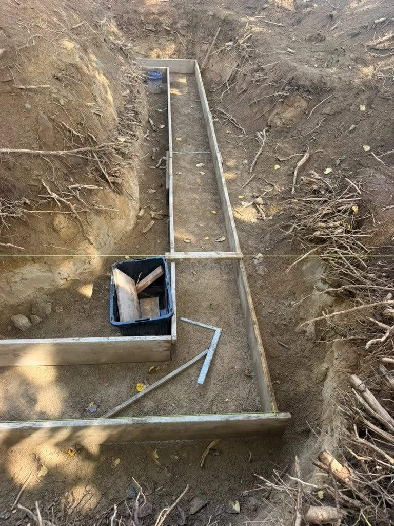 An excavated footing trench with wooden forms